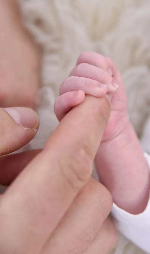 Zarte Babyfüße in liebevollen Händen gehalten